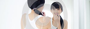 Beautiful young asian woman applying lipstick red on mouth, beauty girl looking facial at mirror for makeup cosmetic.