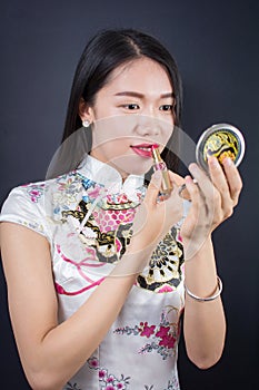 Beautiful young asian woman applying makeup