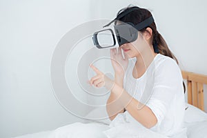 Beautiful young asian woman cheerful and fun wearing vr virtual reality headset, girl device and watching simulator game