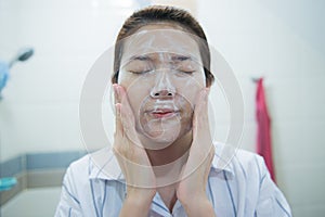 Beautiful young asian woman cleaning face skin