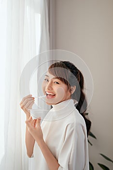 Beautiful of young Asian woman eating yogurt