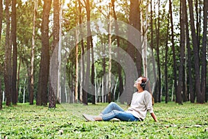 A beautiful woman enjoy listening to music with headphone with feeling happy and relaxed in the park