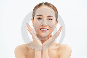Beautiful young Asian woman with fresh clean skin that touches her face with both hands. Spa, cosmetology and beauty