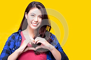 Beautiful young asian woman giving love or heart to customer or people by using hands for making heart shaped with smiley face.