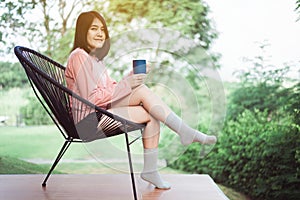 Beautiful young asian woman holding and drinking a cup of coffee in the morning,Enjoys of resting time