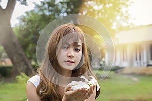 Beautiful young asian woman holding a white flowers in park