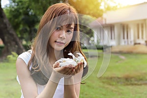 Beautiful young asian woman holding a white flowers in park