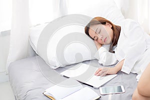 Beautiful young asian woman with laptop lying down in bedroom, girl tired sleep with computer notebook