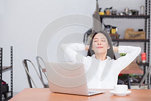 Beautiful young asian woman with laptop stretch and exercise relax after work success.