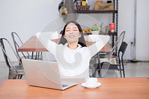 Beautiful young asian woman with laptop stretch and exercise relax after work success.