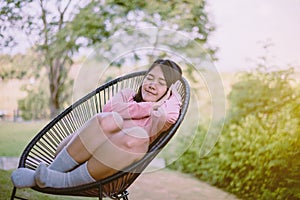 Beautiful young asian woman lying down with hands on her head and sleeping on modern chair at outdooe,Relaxing time,Happy and smil
