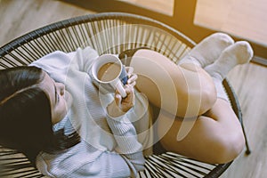 Beautiful young asian woman lying down on sofa bed and drinking hot coffee in bedroom at home,Enjoys of resting time,Top view