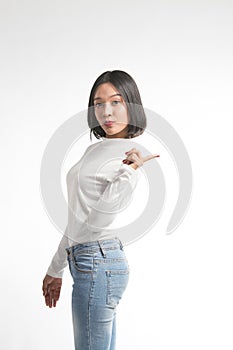 Beautiful young asian woman pointing at whitespace