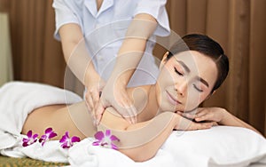 Beautiful young Asian woman relaxing with hand massage on naked back body by masseur at beauty spa treatment. relaxing massage
