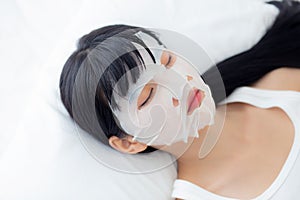 Beautiful young asian woman with sheet facial mask and sleep on bed at bedroom.