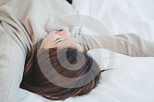 Beautiful young Asian woman sleeping in bed in the morning. Attractive asian girl use bedtime in her comfortable bedroom.