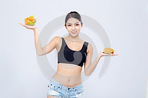 Beautiful young asian woman slim shape with diet choosing fresh salad vegetable and hamburger isolated