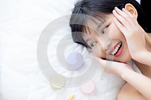 Beautiful of young asian woman smiling and lying on bed with cosmetic at bedroom, beauty of girl with hygiene and healthy.