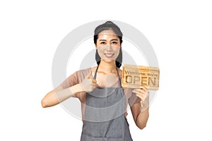 Beautiful young asian woman smiling pretty teeth wearing a apron.Woman holding a wooden sign pointing and thumbs up