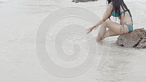 Beautiful young asian woman splash water with hand in seaside, girl in bikini sexy leisure in vacation on the beach in summer.