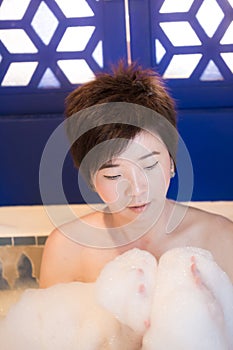 Beautiful young asian woman takes bubble bath