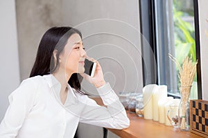 Beautiful young asian woman talking phone and smile in the coffee shop, businesswoman sitting in cafe free time, freelancer