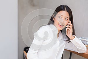 Beautiful young asian woman talking phone and smile in the coffee shop