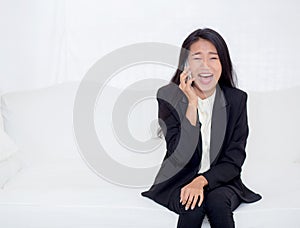 Beautiful young asian woman talking phone and smile in the living room