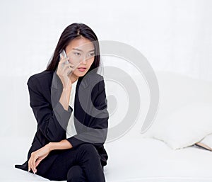 Beautiful young asian woman talking phone and smile in the living room, businesswoman sitting on sofa