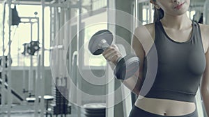 Beautiful young asian woman training workout with strong at gym, asia girl bodyweight with lifting dumbbell at fitness