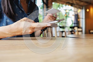 Beautiful young asian woman using smartphone and holding card for shopping online payment . Shopping concept with copy space.