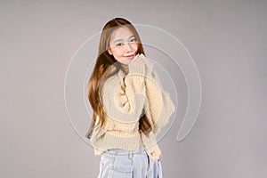 Beautiful young Asian woman in warm knitted green sweater standing, warm winter cold season fashion accessories trend, posing and
