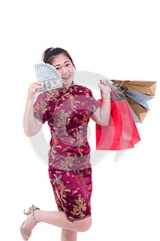 Beautiful Young asian woman wear chinese dress traditional cheongsam or qipao with Carrying a shopping bag and dollar banknote.