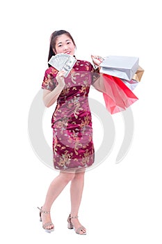 Beautiful Young asian woman wear chinese dress traditional cheongsam or qipao with Carrying a shopping bag and dollar banknote