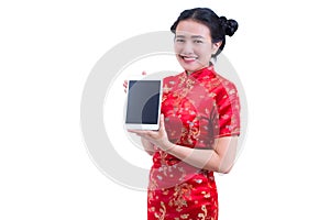 Beautiful Young asian woman wear chinese dress traditional cheongsam or qipao. Hand holding blank screen digital tablet.