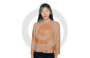 Beautiful young asian woman wearing casual winter sweater smiling looking to the side and staring away thinking