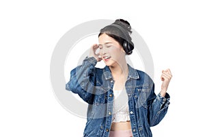 Beautiful young asian woman wearing jeans joyful listening to music on headphones isolated on white background studio portrait