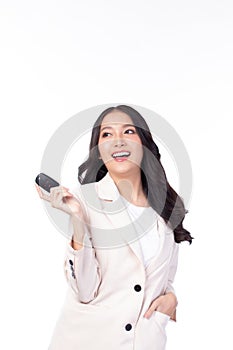 Beautiful young Asian woman wearing suit feeling happy and smile holding the keys of the car on white background