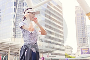 Beautiful young asian woman with white towel resting after workout sport exercises outdoors