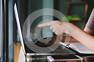 Beautiful young Asian woman working at a coffee shop with computer laptop