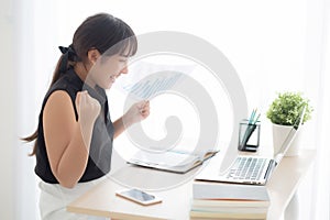 Beautiful young asian woman working laptop computer at office, businesswoman looking graph diagram analysis statistic data