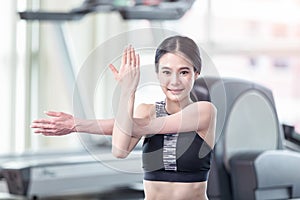 Beautiful young asian woman working out in gym and doing yoga exercise on blue mat