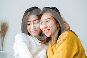 Beautiful young asian women LGBT lesbian happy couple sitting on bed hugging and smiling together in bedroom at home.