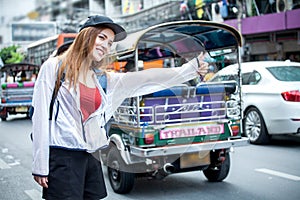 beautiful Young Asian women tourist traveler smiling with backpack on the Traffic Road raising hand calling cab in China town