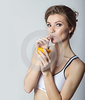 Beautiful young athletic girl energetic happy drinking orange juice, healthy lifestyle