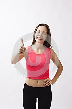 Beautiful young athletic girl shows thumbs up