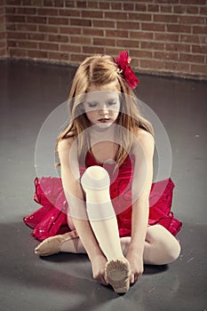 Beautiful young ballerina getting ready for class