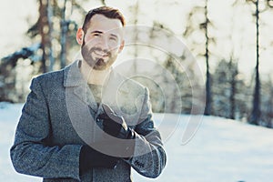 Beautiful young bearded men relaxing on winter walk in snowy forest, candid capture