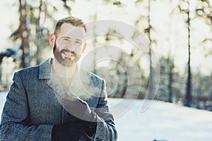 Beautiful young bearded men relaxing on winter walk in snowy forest, candid capture