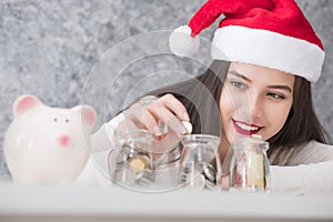 Beautiful young beautiful girl saving money for Christmas and holiday season